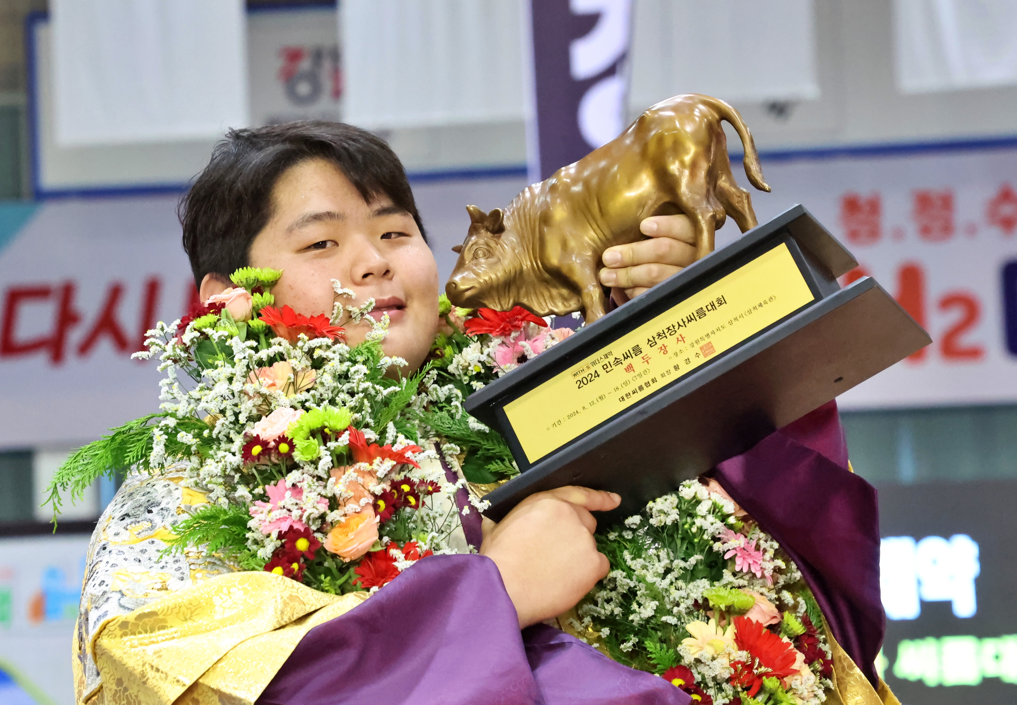 김민재가 18일 삼척장사씨름대회 백두장사 결정전에서 우승한 뒤 황소 트로피를 들고 웃고 있다. 대한씨름협회 제공