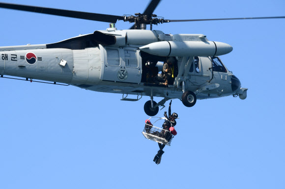 해군1함대사령부 6구조작전중대 소속 심해잠수사가 19일 강원도 동해 군항 인근 해상에서 구조용 바구니를 이용해 조난자를 구조하고 있다. 2024.8.19. 해군 제공