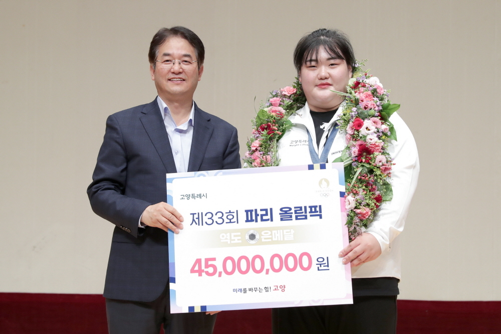 이동환 고양시장(왼쪽)이 파리올림픽 은메달리스트 박혜정 선수에게 축하격려금을 전달하고 기념사진을 찍고 있다.[고양시 제공]