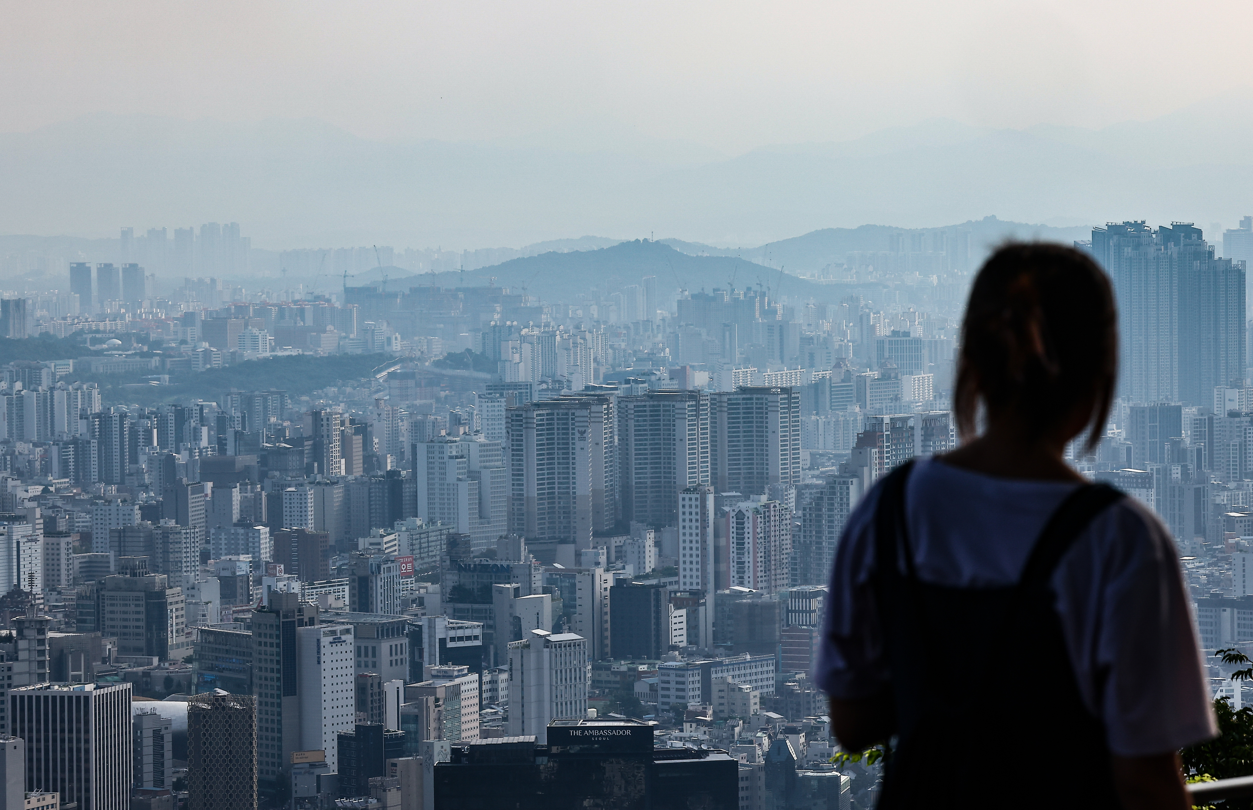 지난 20일 한 시민이 서울 중구 남산에서 서울 시내 아파트와 주택 단지를 보고 있다. 뉴시스