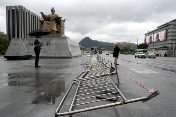 Fences are laid down by government in preparation for an approaching tropical depression which was weakend from Tropical Storm Jongdari, on Gwanghwamun Square in Seoul, South Korea, Wednesday, Aug. 21, 2024. AP