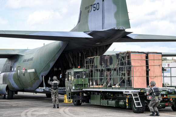 공군 군수사령부 예하 제601종합 수송지원대대 장병들이 22일 대구 동구 대구공군기지 활주로에서 카고로더를 이용해 패트리어트·천궁 모의탄이 실린 화물운반대를 C-130J 수송기에 적재하고 있다. 2024.8.22  공군 제공