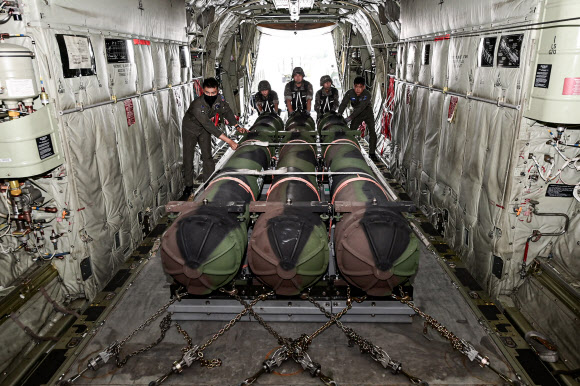 공군 군수사령부 예하 제601종합 수송지원대대 장병들이 22일 대구 동구 대구공군기지 활주로에서 카고로더를 이용해 패트리어트·천궁 모의탄이 실린 화물운반대를 C-130J 수송기에 적재하고 있다. 2024.8.22  공군 제공