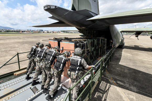 공군 군수사령부 예하 제601종합 수송지원대대 장병들이 22일 대구 동구 대구공군기지 활주로에서 카고로더를 이용해 패트리어트·천궁 모의탄이 실린 화물운반대를 C-130J 수송기에 적재하고 있다. 2024.8.22  공군 제공