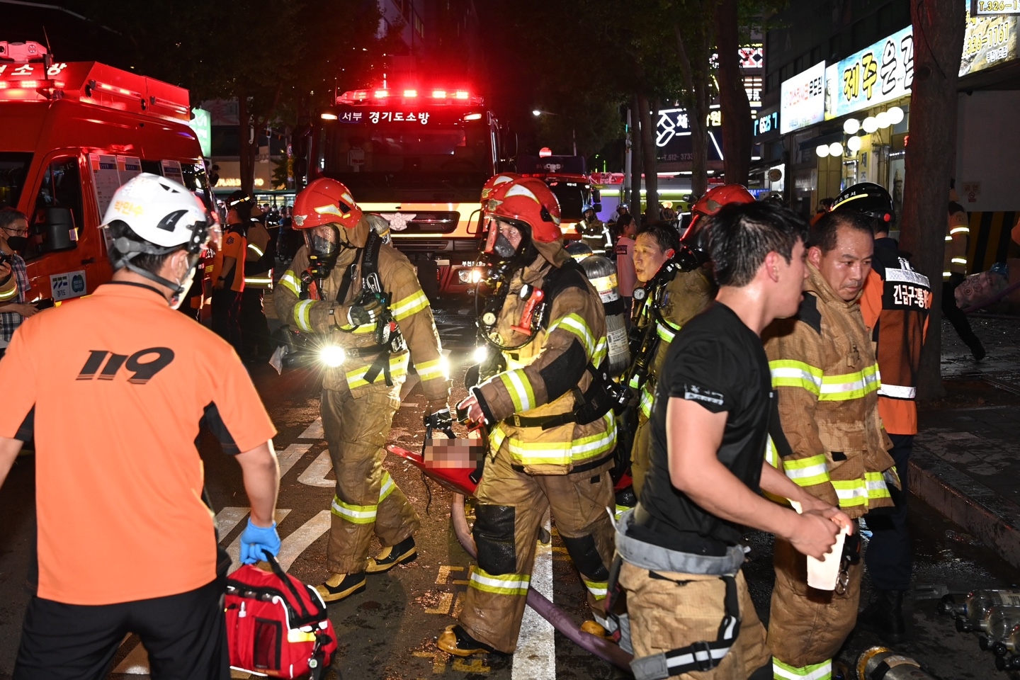 22일 오후 경기 부천 모 호텔의 화재 현장에서 소방대원들이 환자를 이송하고 있다. 2024.8.23 부천시 제공