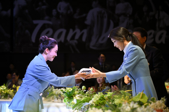 김건희 여사가 22일 서울 중구 신라호텔에서 열린 ‘2024 파리올림픽 선수단 격려 행사’에서 탁구 전지희 선수로 부터 파리올림픽 선수들이 사인한 티셔츠를 선물받고 있다. 2024.8.22. 대통령실 제공