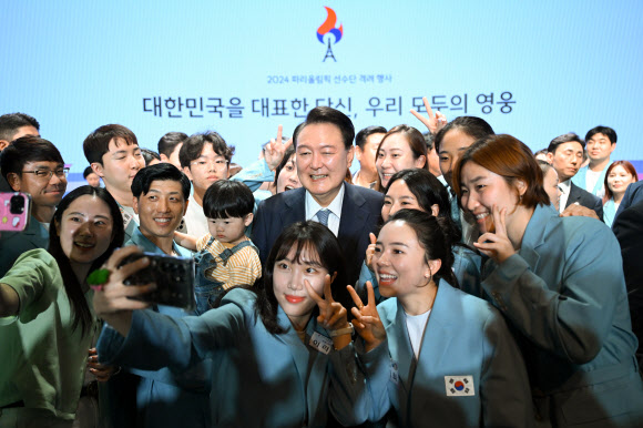 윤석열 대통령이 22일 서울 중구 신라호텔에서 열린 ‘2024 파리올림픽 선수단 격려 행사’에서 선수들 및 참석자들과 셀카를 찍고 있다.    2024.8.22. 대통령실 제공