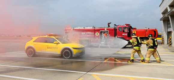 23일 서울 강서구 김포공항 항공기 이동지역에서 열린 한국공항공사 전기차 화재 소방 훈련에서 공항소방대가 화재 차량에 초기 방수를 하고 있다. 2024.8.23. 한국공항공사 제공
