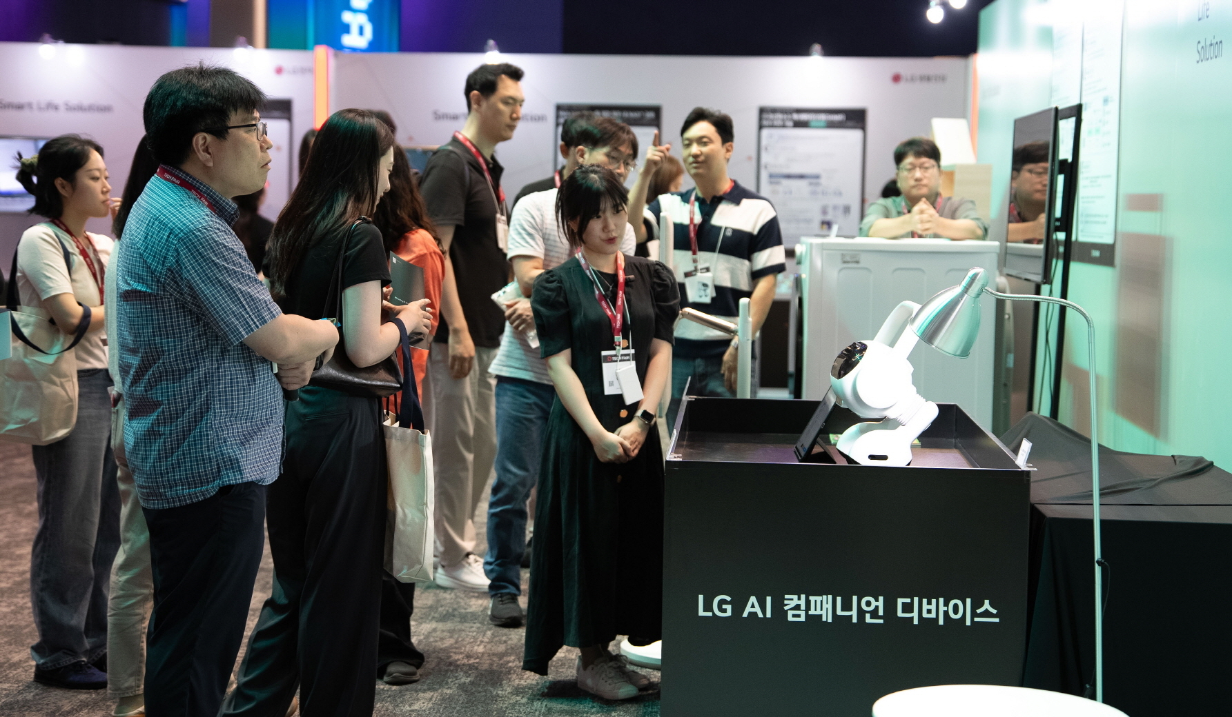 LG 직원들이 집안일을 도와주는 인공지능(AI) 로봇 ‘LG AI 컴패니언 디바이스’에 대한 설명을 듣는 모습. LG 제공