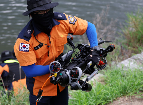 27일 오전 울산시 남구 태화강 십리대밭교 앞에서 열린 울산소방본부의 첨단소방장비 시연회에서 구조대원이 수중로봇(ROV)을 옮기고 있다. 2024.8.27. 연합뉴스