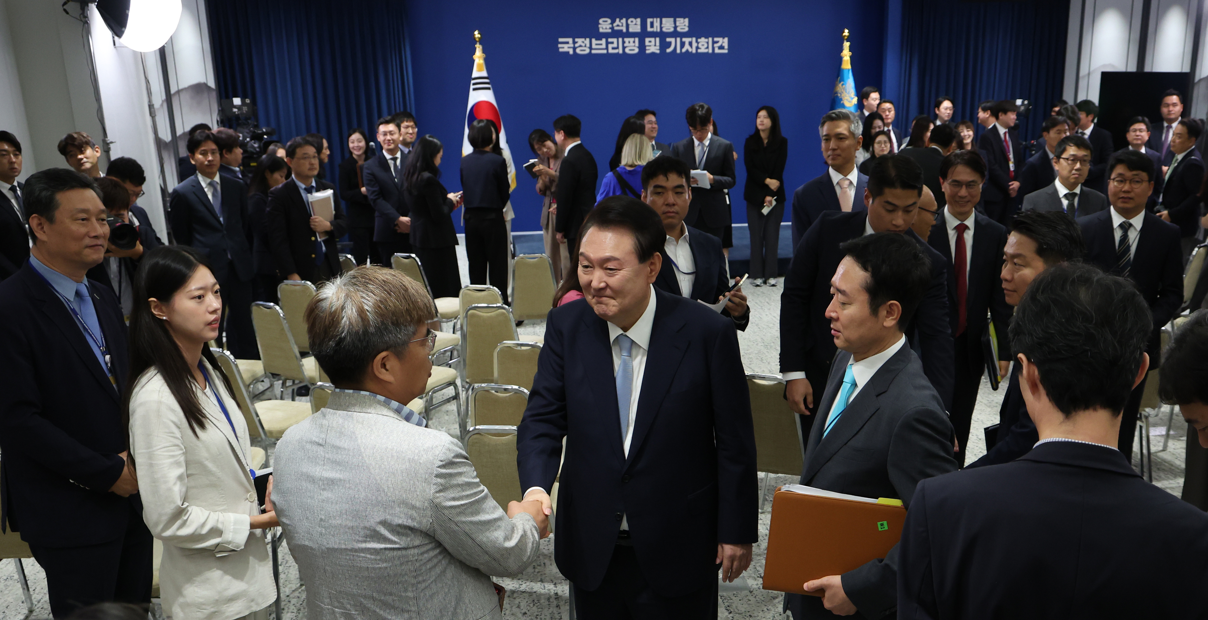 윤석열 대통령이 29일 용산 대통령실 브리핑룸에서 국정브리핑과 기자회견을 마친 뒤 대통령실 출입 기자들과 인사를 나누고 있다. 오른쪽은 이도운 대통령실 홍보수석. 뉴시스