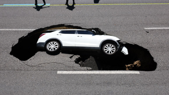 29일 오전 서울 서대문구 연희동 성산로에서 땅 꺼짐 사고로 승용차가 빠져 있다.  이 사고로 승용차 탑승자들이 병원으로 후송됐다. 2024.8.29  연합뉴스