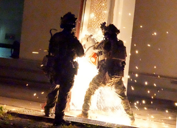 육군특수전사령부가 지난 24일부터 5일간 ‘24 UFS/TIGER의 일환으로 공군 공정통제사(CCT) 및 미국 2전투항공여단 등과 경기 광주시 특수전학교 훈련장에서 연합·합동 특수타격 훈련을 실시했다고 29일 밝혔다. 사진은 연합?합동 특수타격 훈련에서 특전사 장병들이 절단기를 활용해 밀폐된 출입문을 개방하는 모습. 2024.8.29  육군 제공