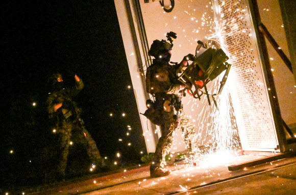 육군특수전사령부가 지난 24일부터 5일간 ‘24 UFS/TIGER의 일환으로 공군 공정통제사(CCT) 및 미국 2전투항공여단 등과 경기 광주시 특수전학교 훈련장에서 연합·합동 특수타격 훈련을 실시했다고 29일 밝혔다. 사진은 연합?합동 특수타격 훈련에서 특전사 장병들이 절단기를 활용해 밀폐된 출입문을 개방하는 모습. 2024.8.29  육군 제공