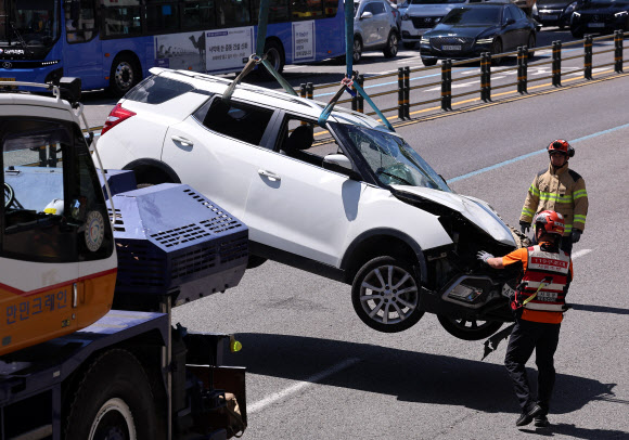 29일 오전 서울 서대문구 연희동 성산로에서 발생한 땅 꺼짐 사고로 빠져버린 승용차가 크레인으로 옮겨지고 있다. 2024.8.29  연합뉴스