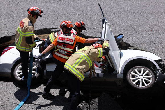 29일 오전 서울 서대문구 연희동 성산로에서 발생한 땅 꺼짐 사고 현장에서 소방 관계자들이 사고 차량을 살펴보고 있다. 2024.8.29  연합뉴스