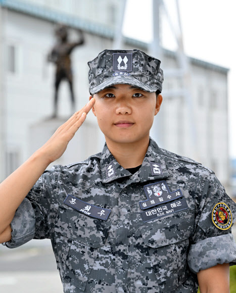 해군이 30일 열린 해난구조전대(SSU) 해난구조 기본과정 수료식에서 장교 9명, 부사관 24명, 병 31명 등 교육생 64명이 수료하고 심해잠수사가 됐다고 밝혔다. 이 가운데 대위 진급이 예정된 문희우 해군 중위는 여군 최초로 심해잠수사 휘장을 거머쥐었다. 사진은 문희우 해군 중위가 ‘세계최강 SSU’ 동상 앞에서 경례하는 모습. 2024.8.30  해군 제공