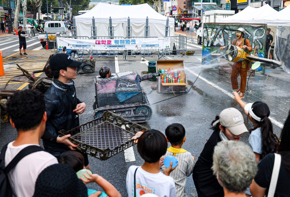 서울 한낮 기온이 32도까지 오르며 더운 날씨를 보인 31일 오후 서울 종로구 혜화역 일대에서 열린 ‘대학로 워터파크’ 행사에서 물싸움 거리극이 펼쳐지고 있다. 2024.8.31. 연합뉴스