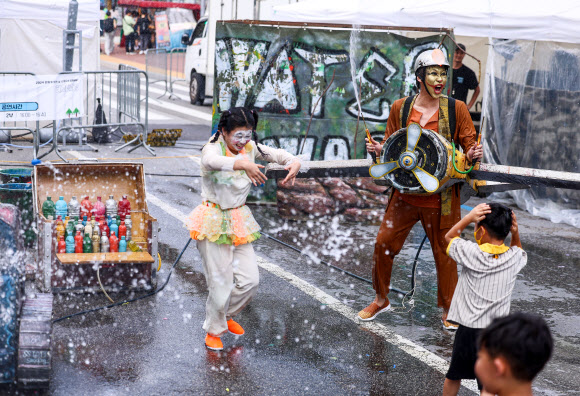 서울 한낮 기온이 32도까지 오르며 더운 날씨를 보인 31일 오후 서울 종로구 혜화역 일대에서 열린 ‘대학로 워터파크’ 행사에서 물싸움 거리극이 펼쳐지고 있다. 2024.8.31 연합뉴스
