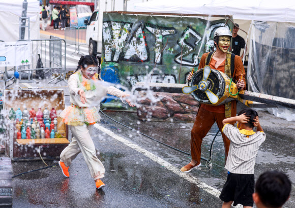 서울 한낮 기온이 32도까지 오르며 더운 날씨를 보인 31일 오후 서울 종로구 혜화역 일대에서 열린 ‘대학로 워터파크’ 행사에서 물싸움 거리극이 펼쳐지고 있다. 2024.8.31. 연합뉴스