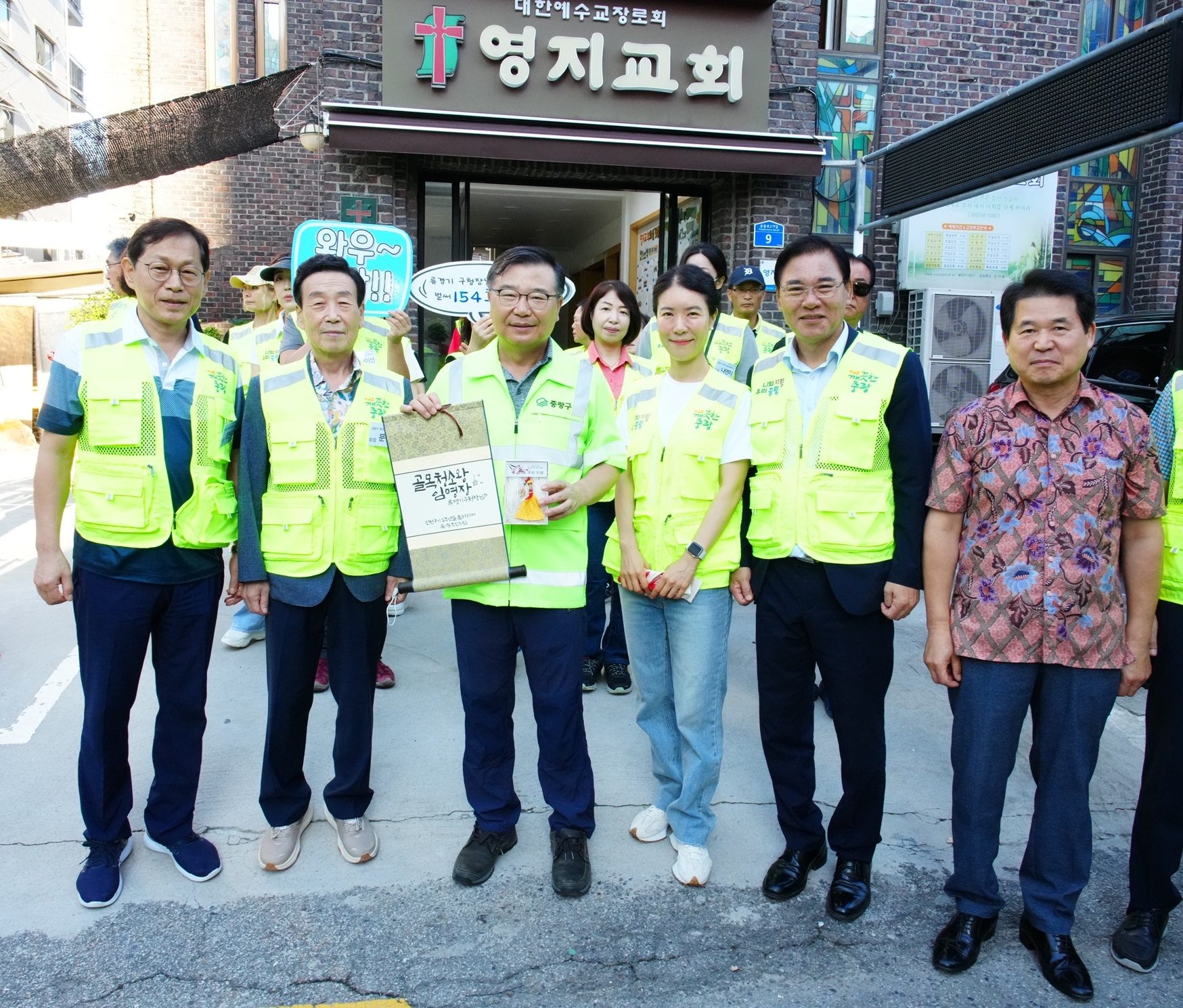 류경기(앞줄 왼쪽 세 번째) 서울 중랑구청장이 지난달 28일 154번째 아침 골목청소를 마친 뒤 구민들로부터 받은 골목청소왕 임명장과 황금색 빗자루를 들고 기념촬영하고 있다. 중랑구 제공