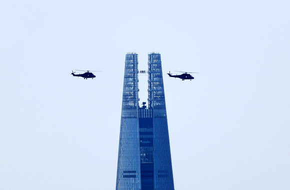 국군의 날을 한 달여 앞둔 3일 오후 서울 송파구 롯데월드타워 인근 상공에서 육군 헬기 편대가 선회 비행 예행연습을 하고 있다. 2024.9.3  연합뉴스