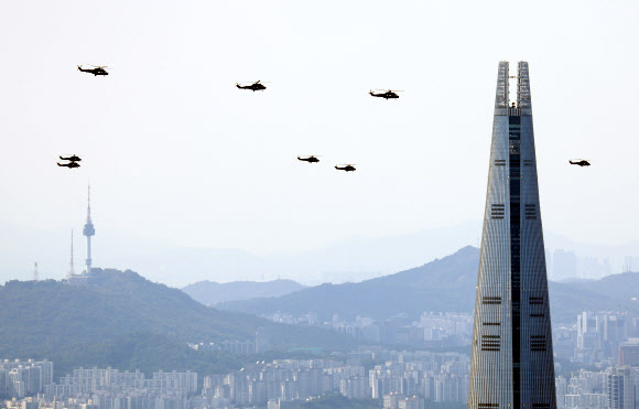 국군의 날을 한달여 앞둔 3일 오후 서울 송파구 롯데월드타워 인근 상공에서 육군 헬기 편대가 선회 비행 예행연습을 하고 있다. 2024.9.3  연합뉴스
