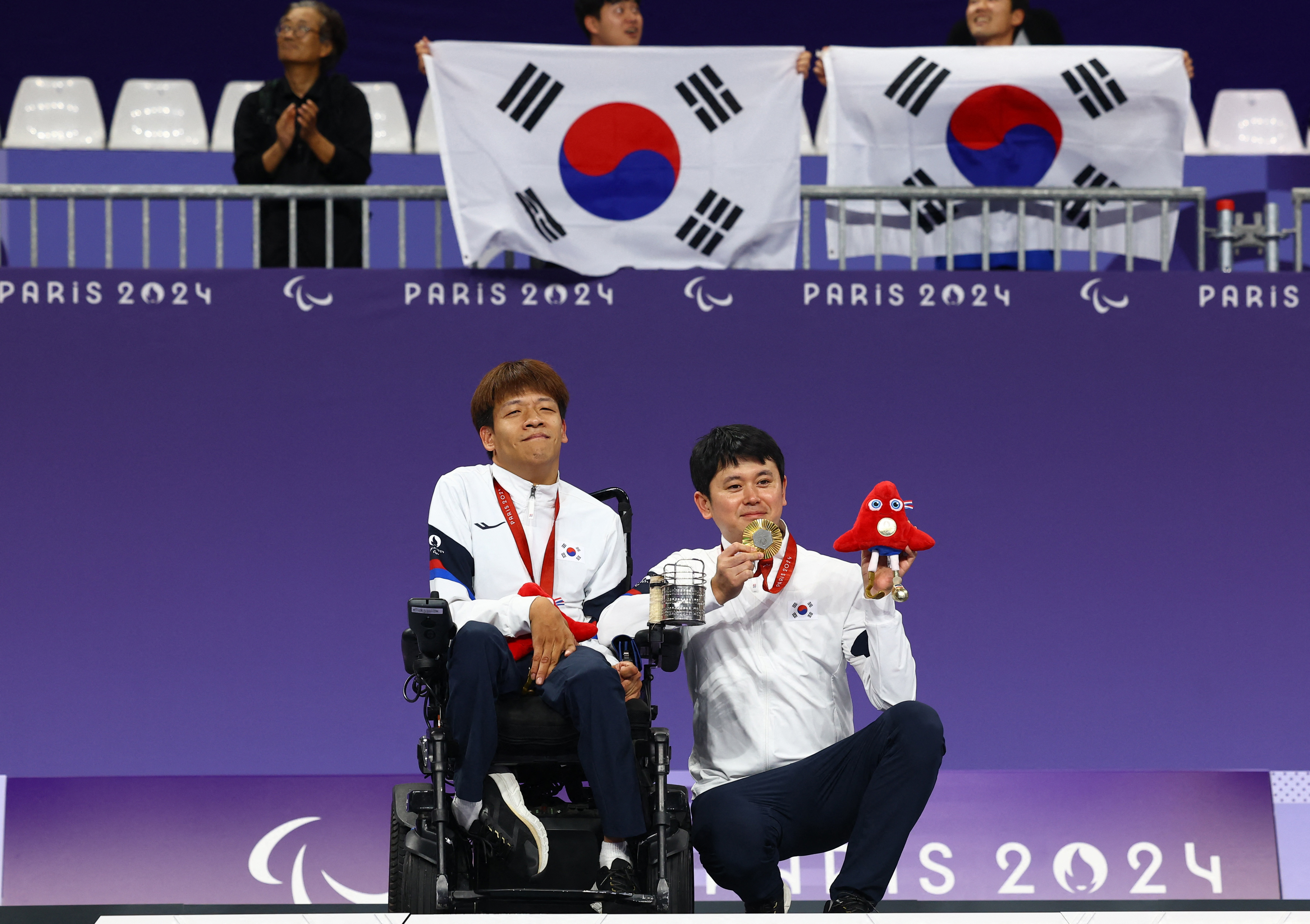 보조 선수인 김승겸(오른쪽) 보치아 대표팀 코치와 함께 시상대 위에 올라 환하게 웃는 정호원의 모습. 파리 로이터 연합뉴스