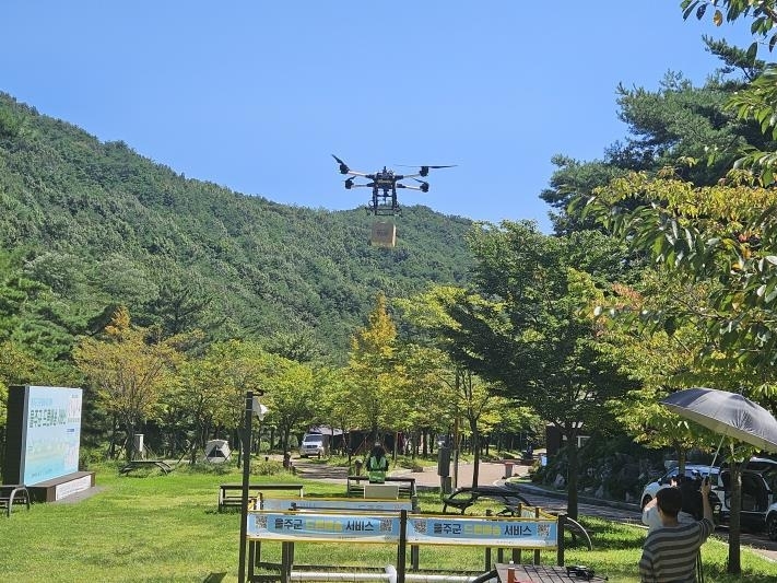 지난 5일 울산 울주군 작천청 드론배송센터에서 날아온 드론이 배송 물품을 별빛야영장에 설치된 그물망 위에 떨어뜨리고 있다. 울주군 제공