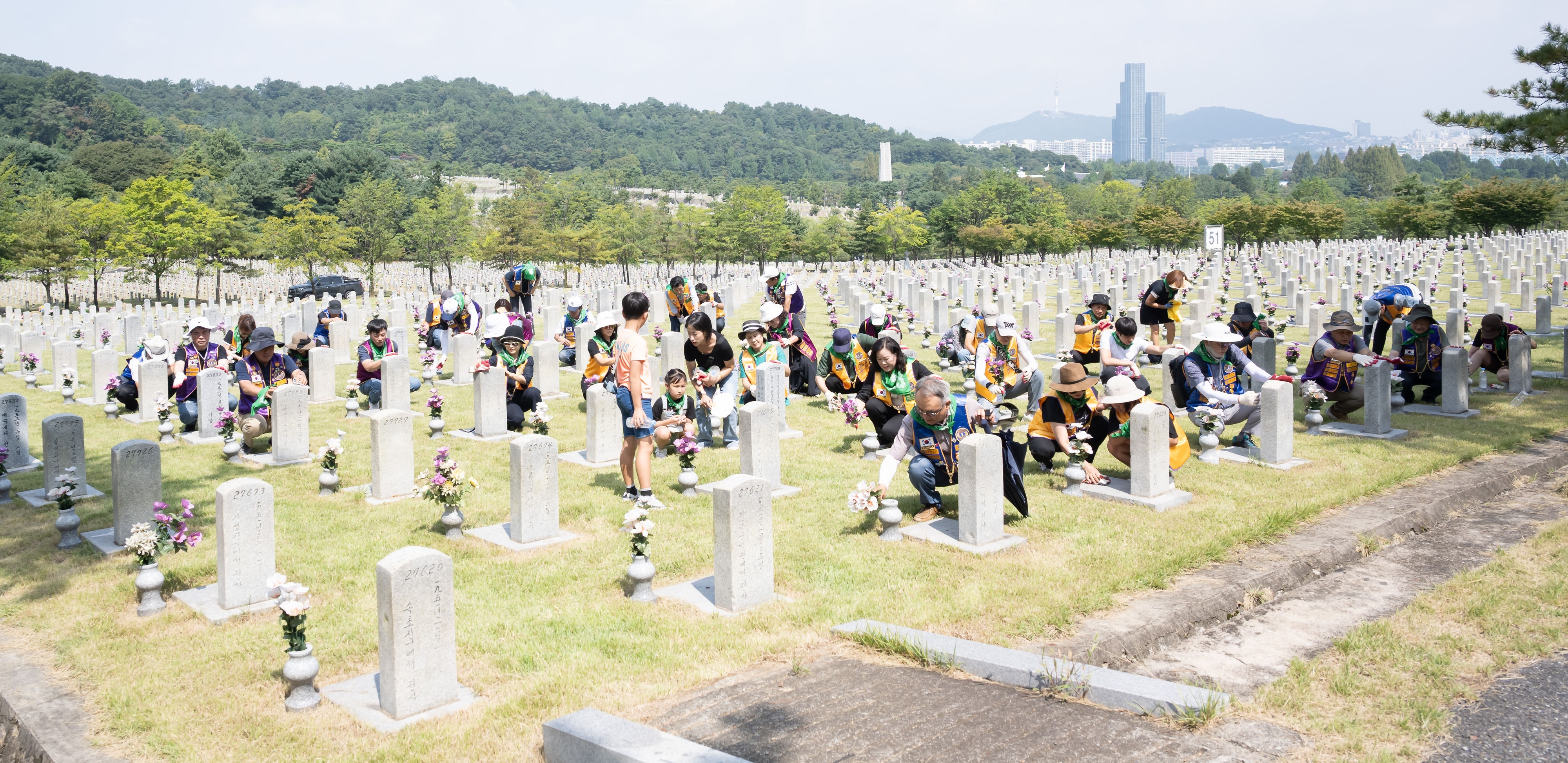 국제라이온스협회 354-D지구 지훈 총재와 회원들이 7일 국립현충원을 참배후 묘역 정비 활동을 하고 있다. [사진 협회 제공]