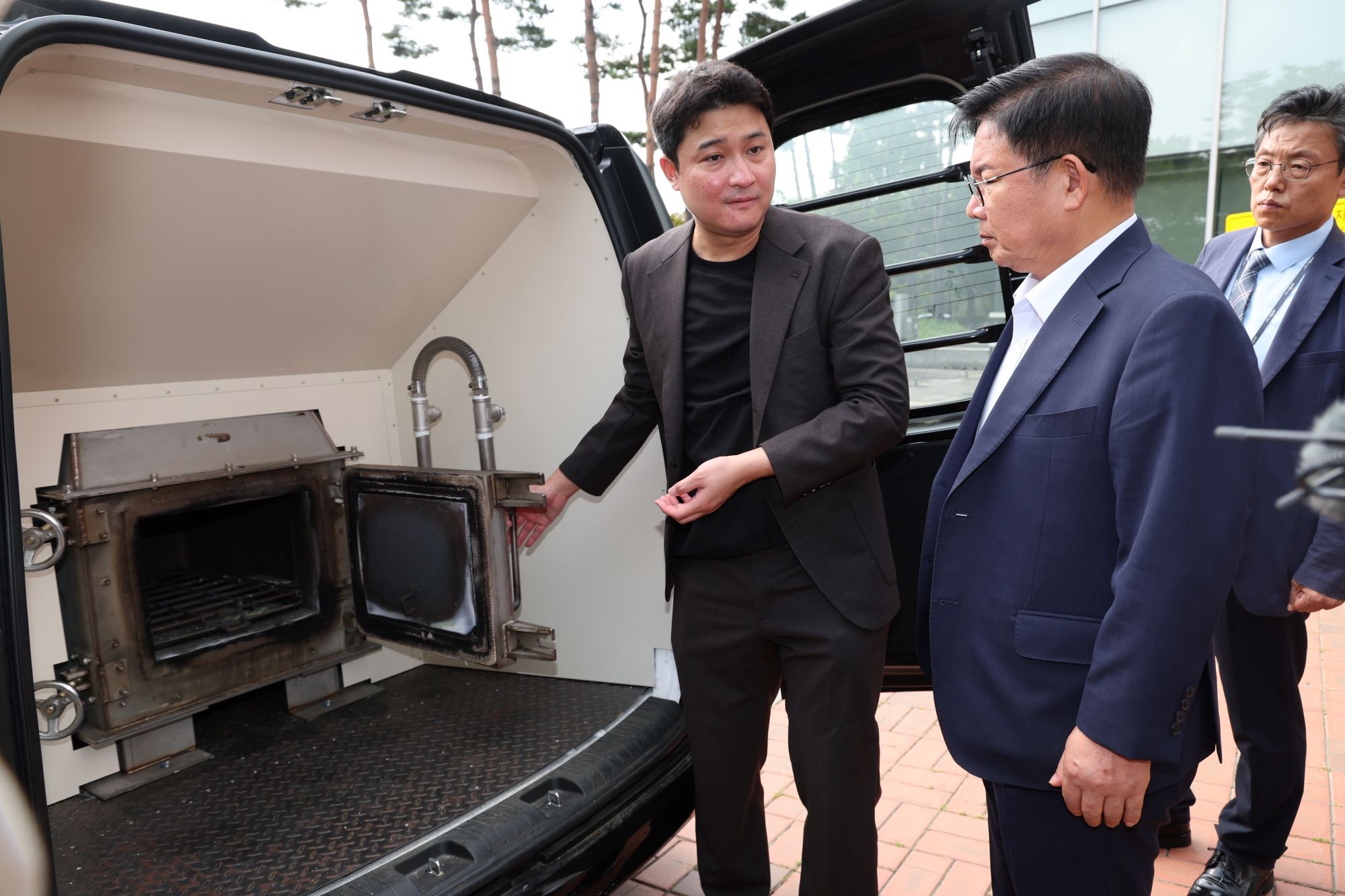 박강수(가운데) 서울 마포구청장이 이동식 반려동물 장례서비스의 무연무취 화장로에 관해 설명을 듣고 있다. 마포구 제공