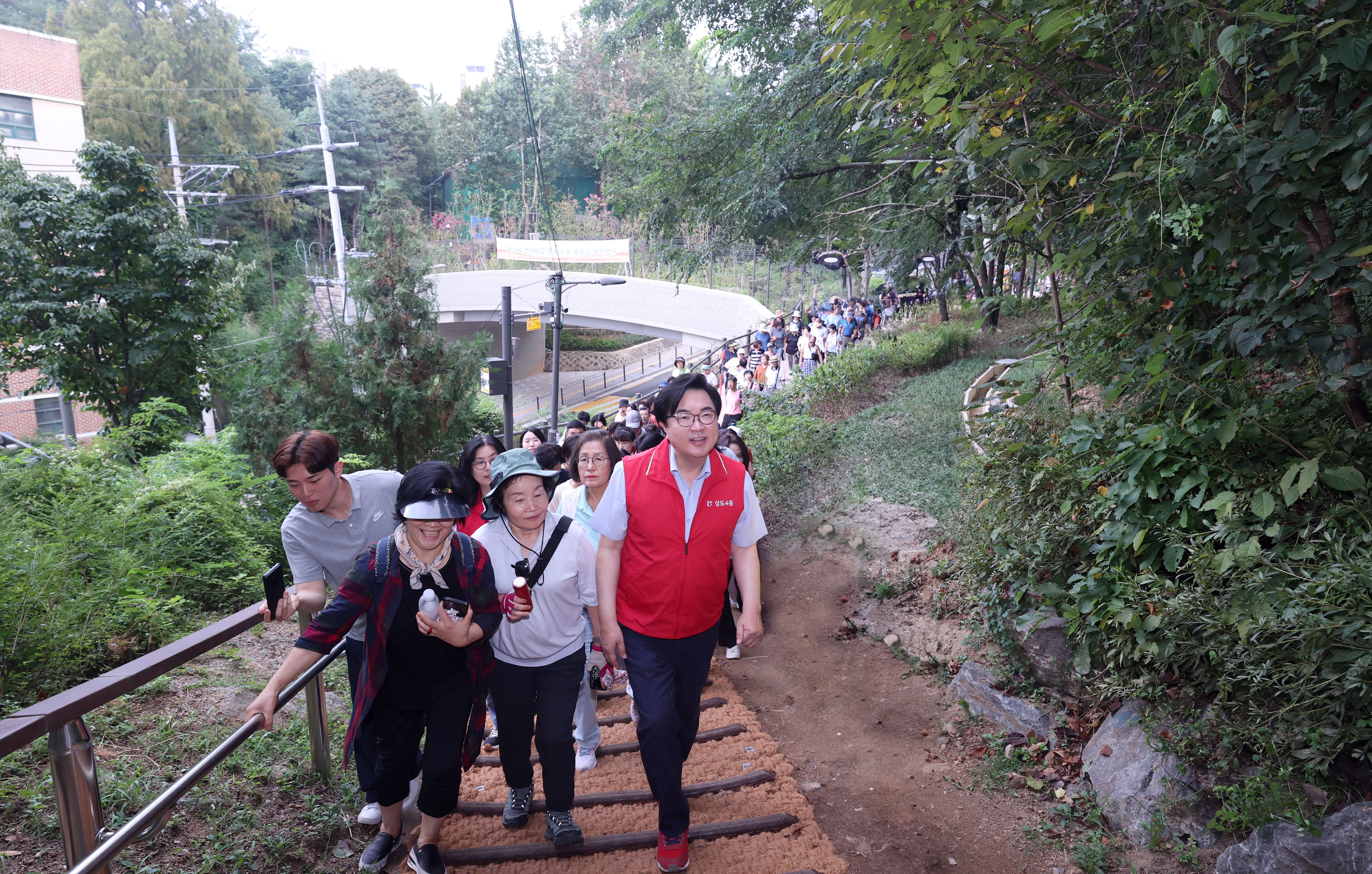 박일하(앞줄 오른쪽 첫 번째) 서울 동작구청장이 지난 9일 국사봉 생태육교 준공식을 마치고 인근 둘레길을 걸으며 현장을 점검하고 있다. 동작구 제공