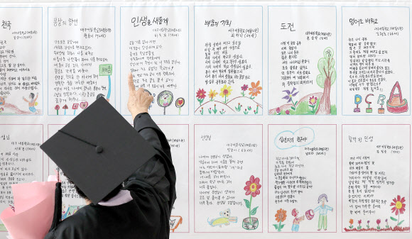 11일 대구 수성구 대구시교육청 행복관에서 열린 대구내일학교 초등 제12회·중학 제9회 졸업식에서 한 졸업생이 졸업 작품인 시화를 살펴보고 있다. 대구내일학교는 배움의 기회를 놓친 만18세 이상 성인에게 초·중학교 학력을 인정받을 수 있도록 돕는 무료 교육과정이다. 2024.9.11. 연합뉴스
