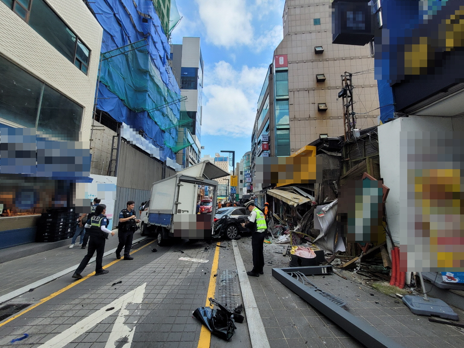 지난 12일 오후 1시쯤 부산 해운대구 해운대어귀삼거리 근처에서 인도로 돌진한 벤츠 차량이 정차 중이던 트럭과 인근 점포를 들이받은 뒤 멈춰 있다. 부산경찰청 제공