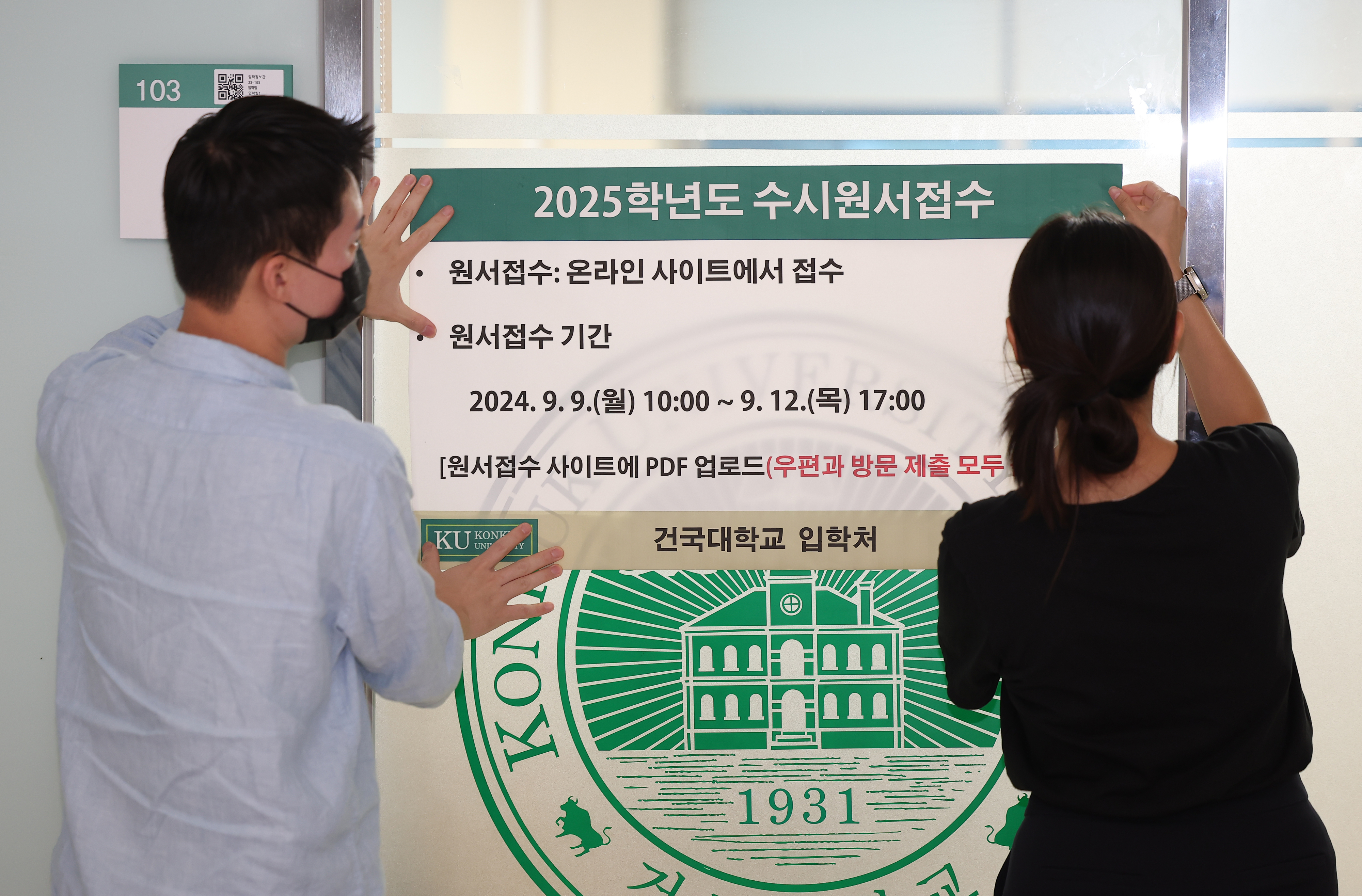 2025학년도 수시 원서 접수가 시작된 9일 오후 서울 광진구 건국대학교 입학정보관에서 학교 직원들이 수시 접수 관련 안내문을 붙이고 있다. 연합뉴스