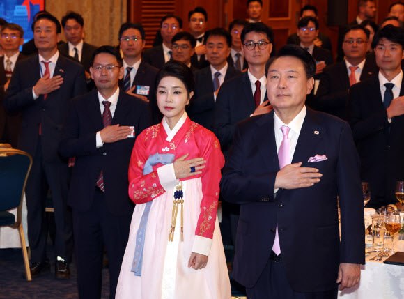 윤석열 대통령과 부인 김건희 여사가 20일(현지시간) 프라하 시내 한 호텔에서 열린 체코 동포 만찬 간담회에서 국기에 경례하고 있다.  2024.9.21. 연합뉴스