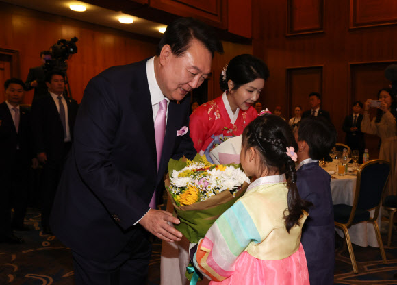 윤석열 대통령과 부인 김건희 여사가 20일(현지시간) 프라하 시내 한 호텔에서 열린 체코 동포 만찬 간담회에서 화동으로부터 꽃다발을 받고 있다. 2024.9.21. 연합뉴스