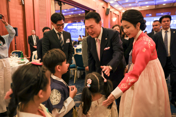 윤석열 대통령과 부인 김건희 여사가 20일(현지시간) 프라하 시내 한 호텔에서 열린 체코 동포 만찬 간담회에서 화동과 이야기를 나누고 있다.  2024.9.21. 연합뉴스
