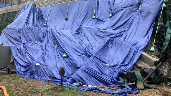 지난 20일부터 이틀간 대전에 171.5㎜의 비가 내린 가운데 21일 무너져 내린 중구 대사동 보문산 인근 옹벽 위에 응급복구 포장이 덮여 있다. 2024.9.21. 연합뉴스