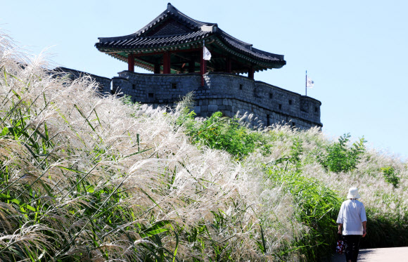 완연한 가을 날씨를 보인 23일 오전 경기도 수원시 세계문화유산 화성(華城)을 찾은 시민들이 서북각루 앞 억새밭 옆 산책로를 걷고 있다. 2024.9.23. 연합뉴스