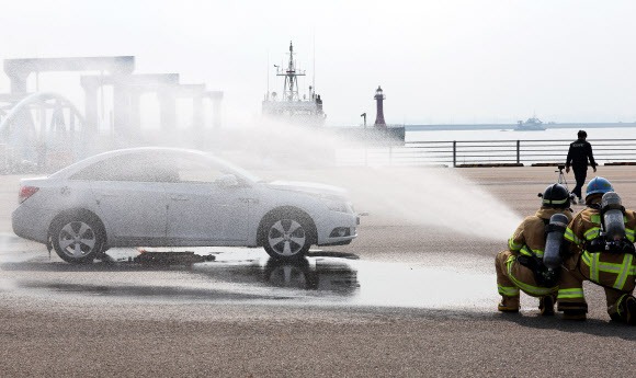 27일 오후 경기도 평택시 포승읍 평택해양경찰서 전용부두에서 열린 ‘전기차 배터리 화재 진압 및 감식 훈련’에서 소방관들이 가상 전기차 화재를 진압하고 있다. 2024.9.27 연합뉴스
