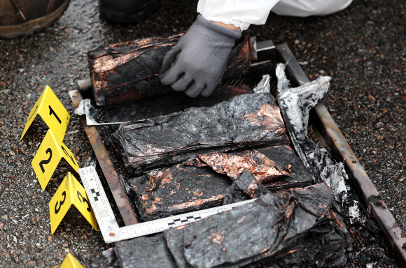 27일 오후 경기도 평택시 포승읍 평택해양경찰서 전용부두에서 열린 ‘전기차 배터리 화재 진압 및 감식 훈련’에서 과학수사관들이 배터리 감식을 하고 있다. 2024.9.27 연합뉴스