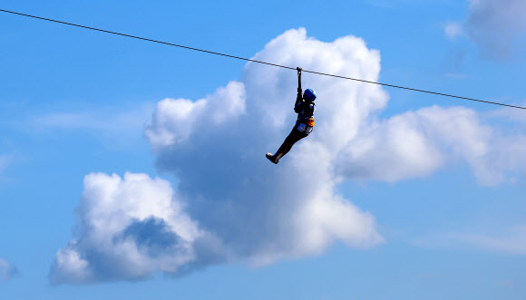 가을이 완연한 29일 강원 강릉시 남대천 하구 바다 위에서 관광객들이 집라인을 즐기고 있다. 2024.9.29  연합뉴스