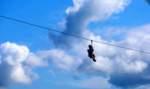 가을이 완연한 29일 강원 강릉시 남대천 하구 바다 위에서 관광객들이 집라인을 즐기고 있다. 2024.9.29  연합뉴스