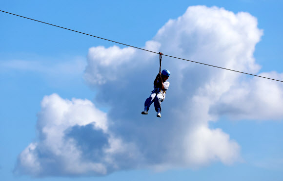 가을이 완연한 29일 강원 강릉시 남대천 하구 바다 위에서 관광객들이 집라인을 즐기고 있다. 2024.9.29  연합뉴스