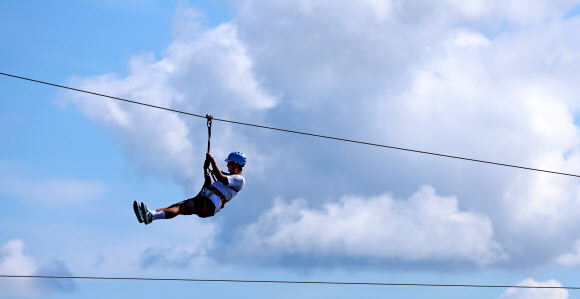 가을이 완연한 29일 강원 강릉시 남대천 하구 바다 위에서 관광객들이 집라인을 즐기고 있다. 2024.9.29  연합뉴스