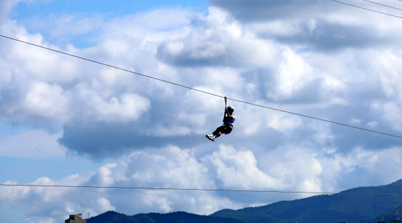 가을이 완연한 29일 강원 강릉시 남대천 하구 바다 위에서 관광객들이 집라인을 즐기고 있다. 2024.9.29  연합뉴스