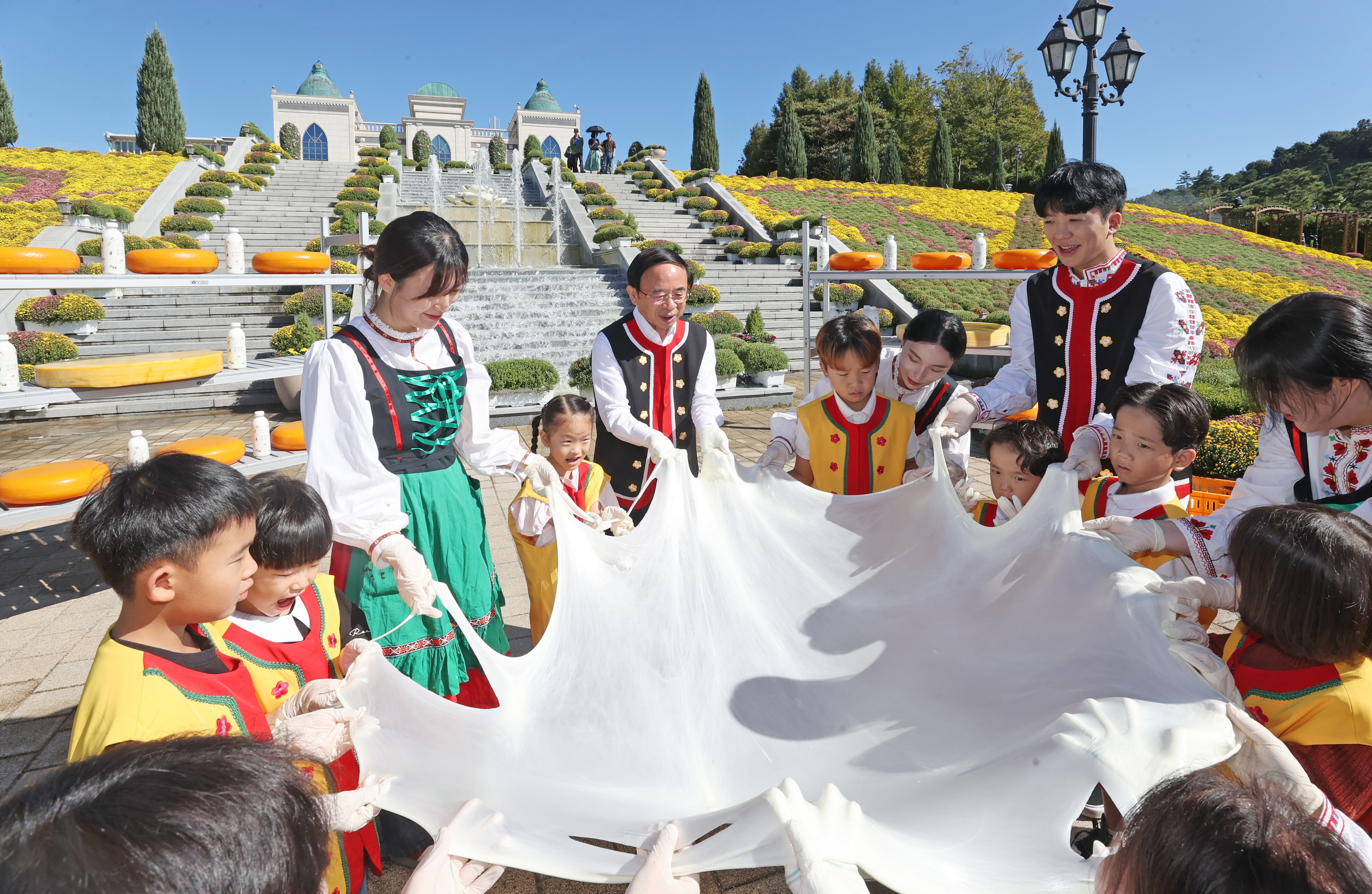 심민 임실군수가 치즈테마파크에서 축제에 참가한 어린이들에게 치즈늘리기 체험을 설명하고 있다. 임실군 제공