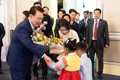 싱가포르를 방문 중인 윤석열 대통령과 김건희 여사가 9일 오후(현지시간) 싱가포르 샹그릴라 호텔에서 열린 동포 오찬 간담회에서 화동으로부터 꽃다발을 받고 있다. 싱가포르 연합뉴스