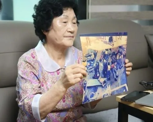 한강 작가의 소설 ‘소년이 온다’의 주인공인 고 문재학군의 어머니 김길자(84)씨가 5·18 희생된 아들 사진을 보여주고 있다. 연합뉴스